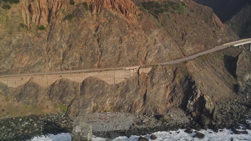 A car drives down a coastal road