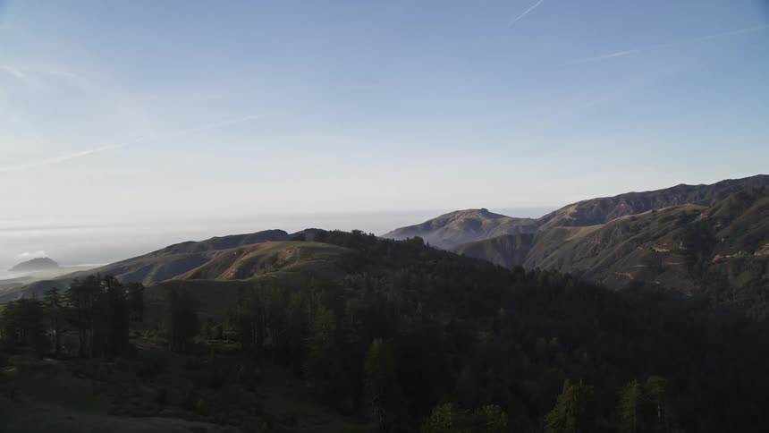 Mountainous landscape with lush vegetation and views of a shrouded ocean