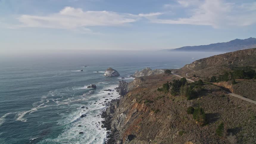 Aerial view of an extensive sea reaching the rocky and mountainous coast