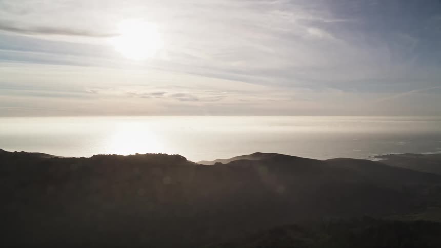 Aerial scenery of the strong sun over the sea and mountains