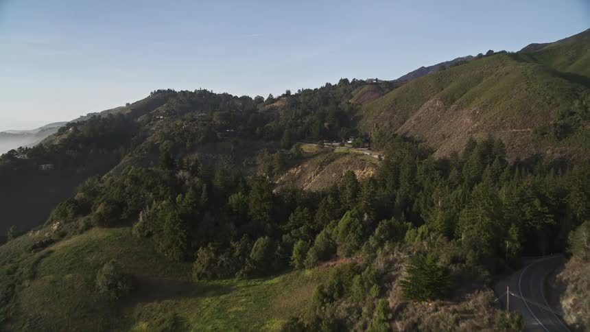 Aerial panorama of mountain ranges with highway on a blue sky day