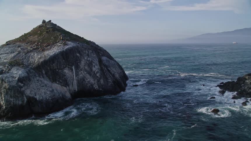 Aerial scenery of a blue sea with rocks and the coast around it