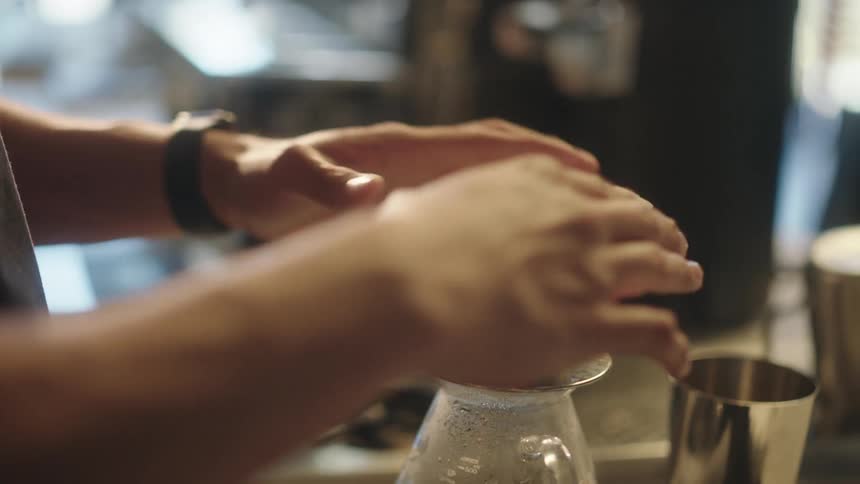 A barista placing a paper filter to brew coffee
