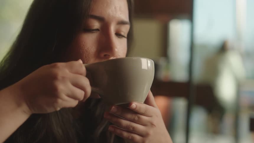 Young woman sitting having a cappuccino