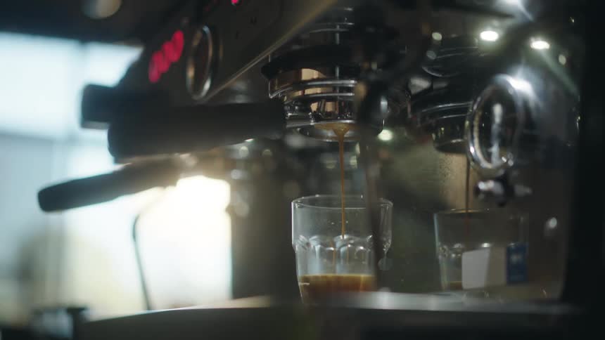 Coffee pours from the machine in the cafe