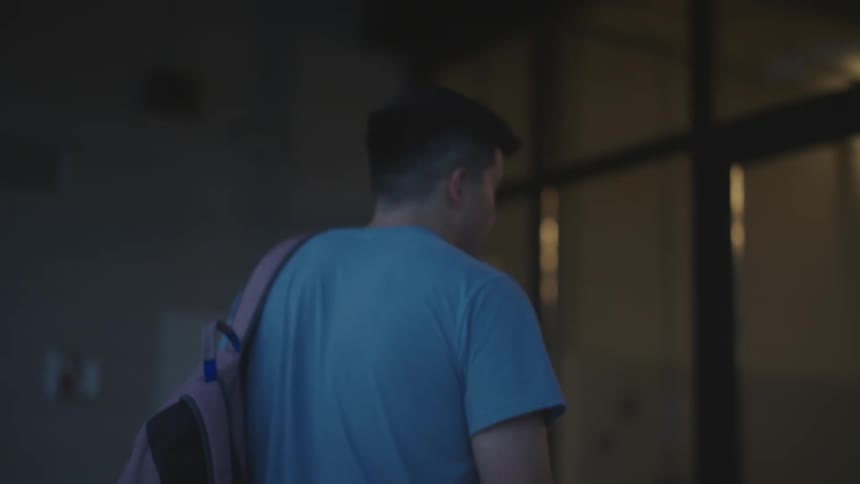 A young man ascends the stairs preparing to enter a building