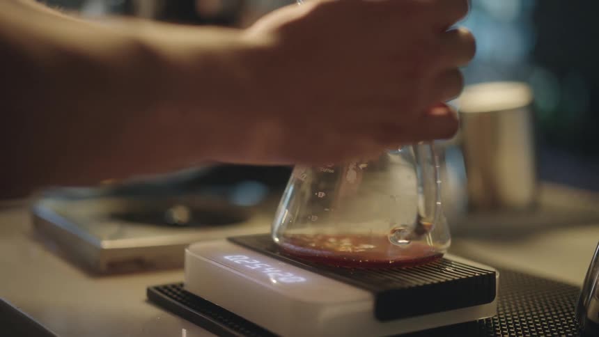 A person is weighting a drink on a scale