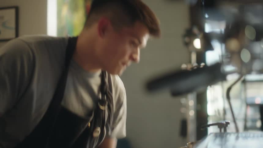 A man pours milk in the cafe