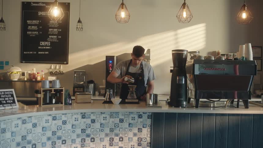 An employee prepares drinks in a cafe