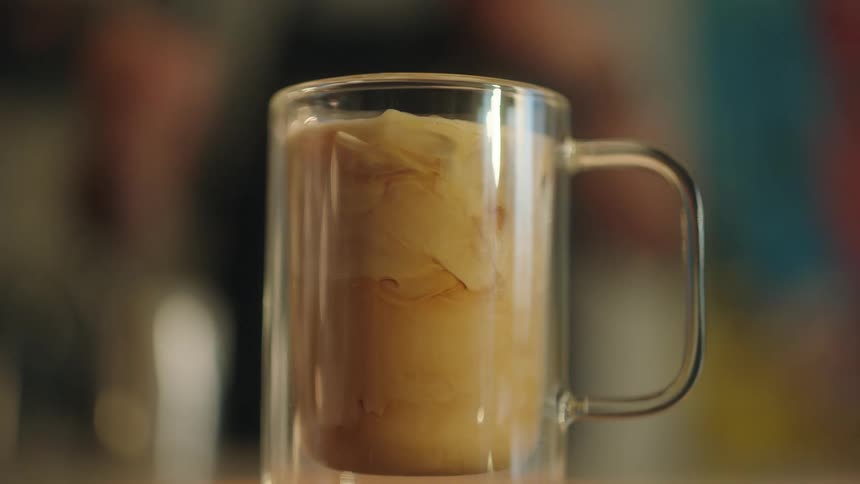An employee prepares a coffee drink at a cafe