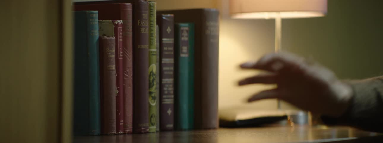 Womans hands arranging books on a shelf
