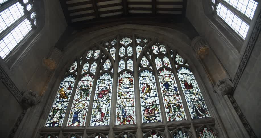 Upward view of the interior of a mirrored church with artistic glass and grayish columns