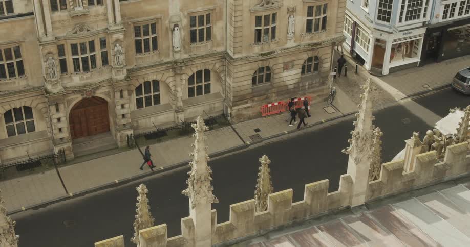 Pedestrians walk in front of the rhodes building oriel college in oxford
