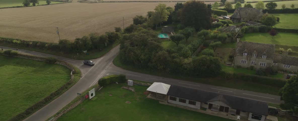 A car drives on the road through the countryside