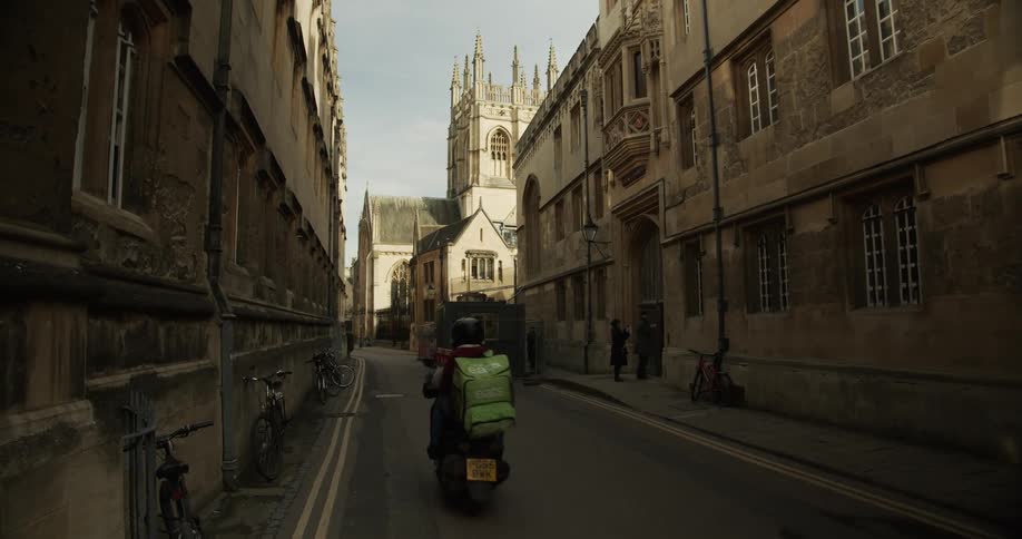 Street in a city with old buildings with motorcycle and pedestrian traffic