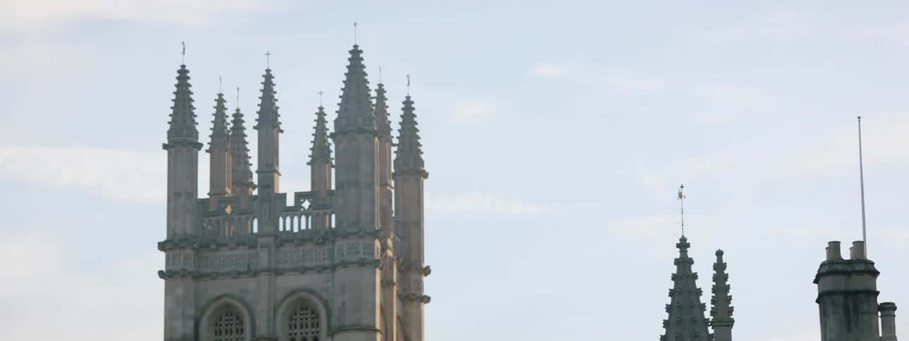 Exterior architecture of the medieval towers of a cathedral on a blue sky day with clouds