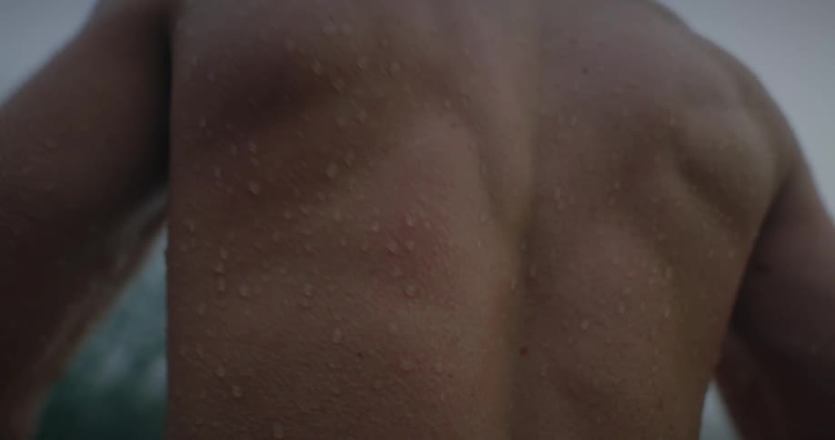 Close up of the wet back of a man having chills
