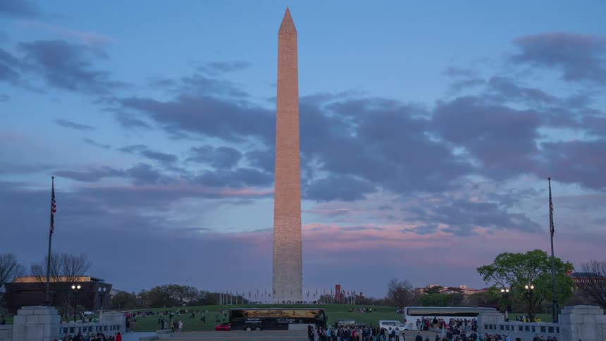 Panorama of washington monument square with tourists and pedestrians and the day getting dark