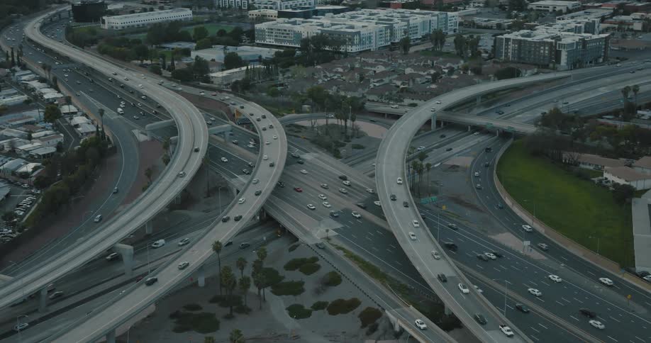 Aerial of vehicles travelling on converging highways in a metropolis