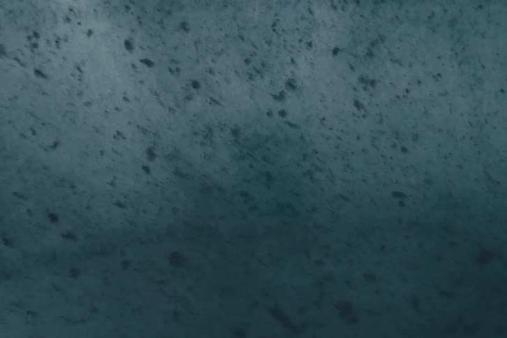 Extreme closeup on a dense liquid with abstract dirt