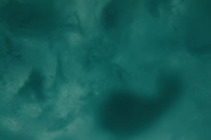 Close up of blue fuzzy particles floating and swirling