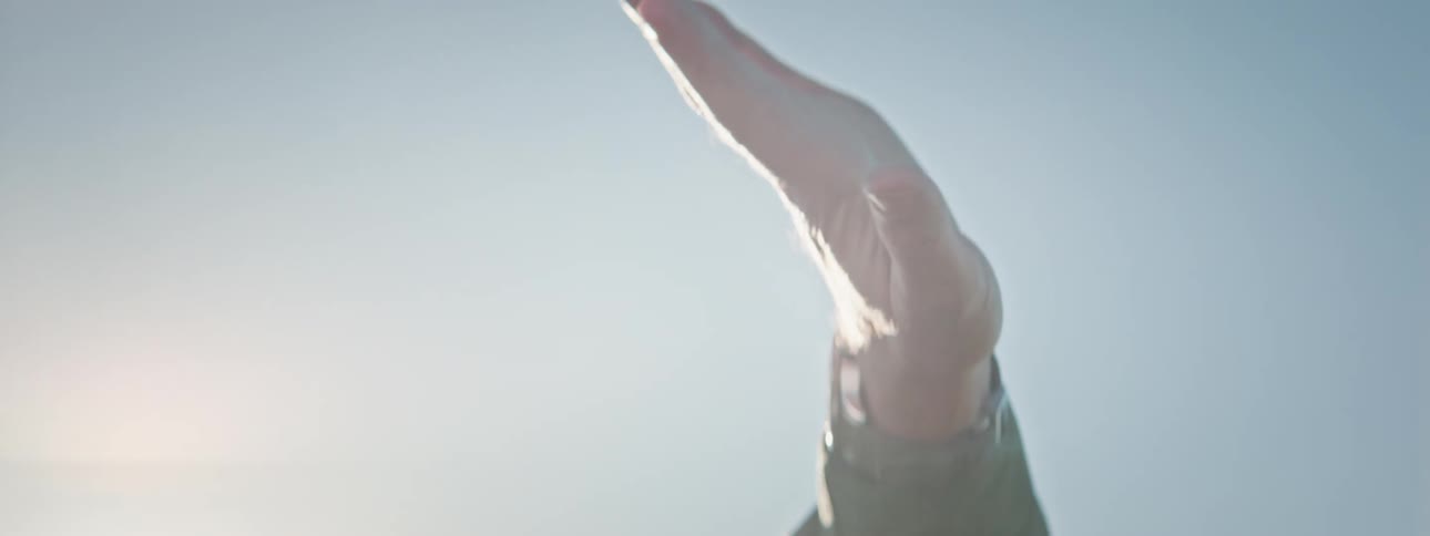 Hand of a man with open palms pointing to the sky in motion