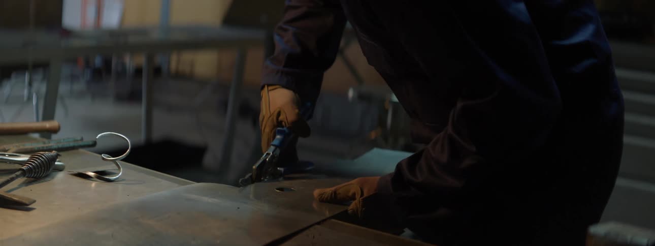 A worker cuts a piece of metal