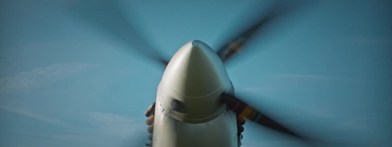 An airplane with a single propeller starts up and the propeller spins