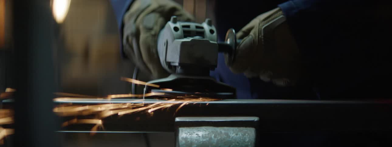 A man grinding a piece of metal with an angle grinder