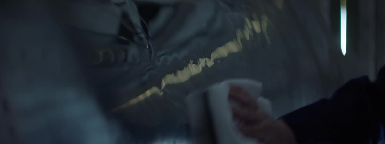 A person polishes a shiny surface