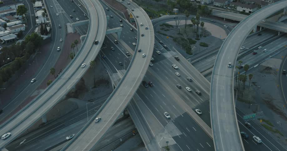 Aerial of vehicles travelling on converging highways in a metropolitan area