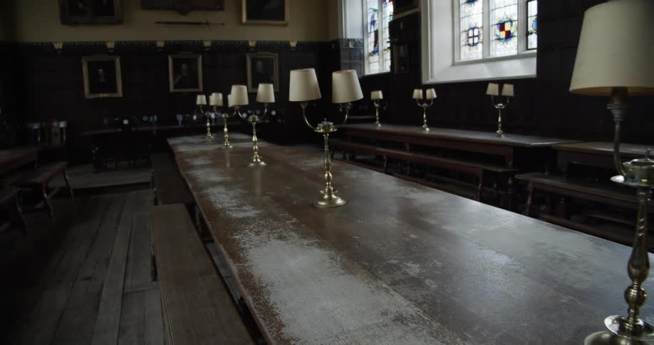A row of brass lamps with colorful glass shades sits on a long wooden table