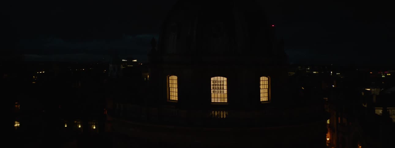 A building in a city with windows illuminated by lights at night