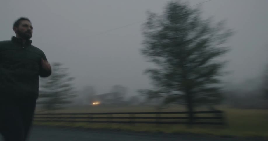 Man jogging on a rural road on a foggy morning