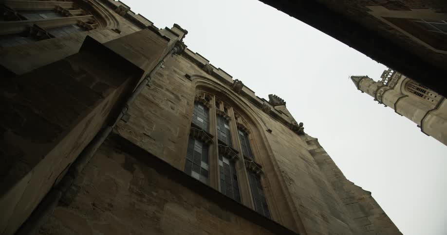 Exterior view of architecture upwards in an alley of a cathedral on a cloudy day