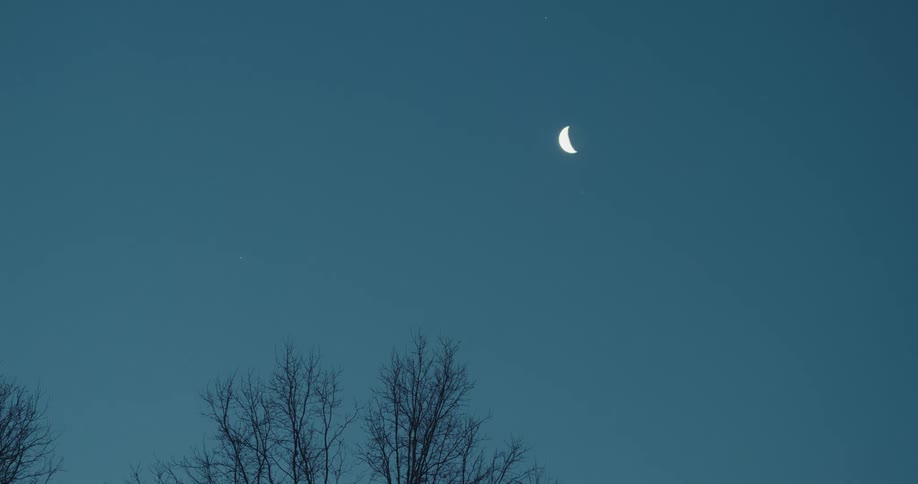 View of the blue sky with the moon and the shadow of a person running past
