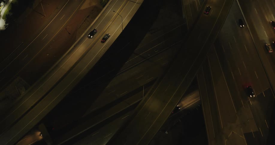 View from above of a viaduct and streets with vehicle traffic at night