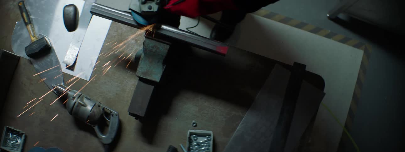 Hands of a man working on a machine performing metal polishing