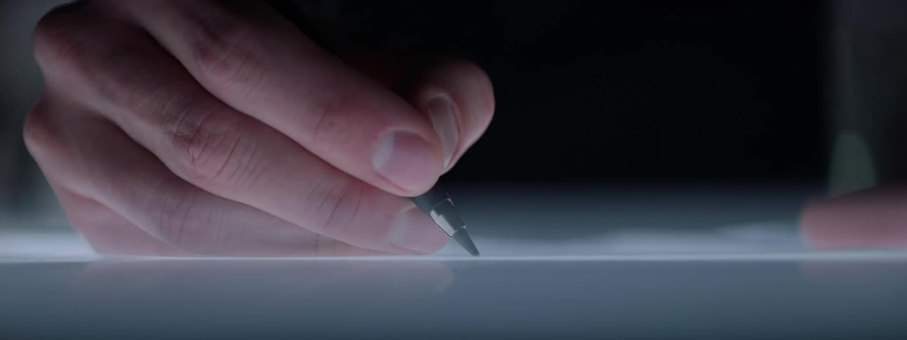 Close up of a person writing over a flashing reflective surface