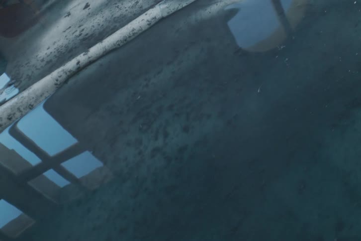 Close up of water washing over a dirty floor
