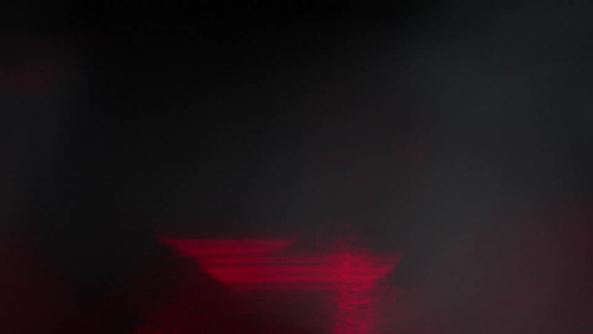 Close up of out of focus reflections of red lights at night