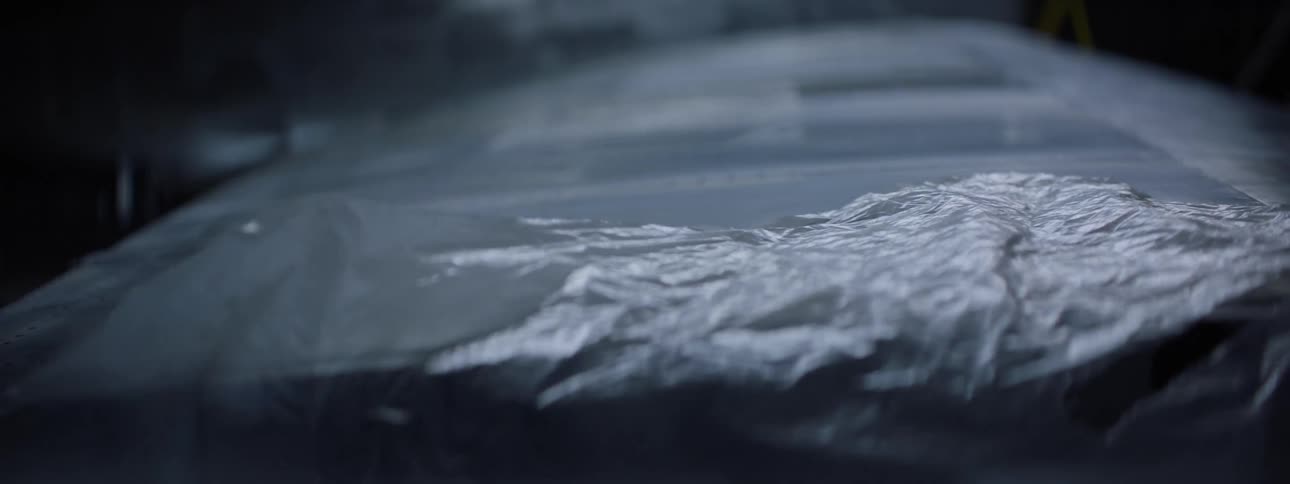Removing a translucent plastic cover from a dark surface