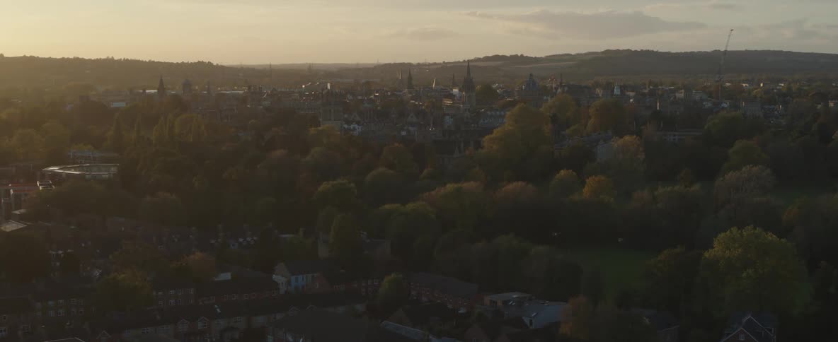 Panorama of an urban city with spring trees and mountains in the horizon