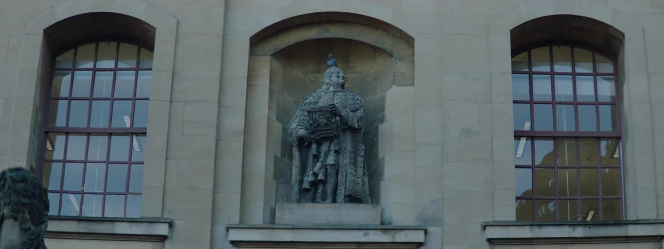 Artistic monument on a wall with a dove on top and rustic windows on the side