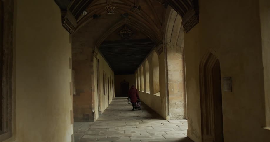 A person walks down an enclosed hallway