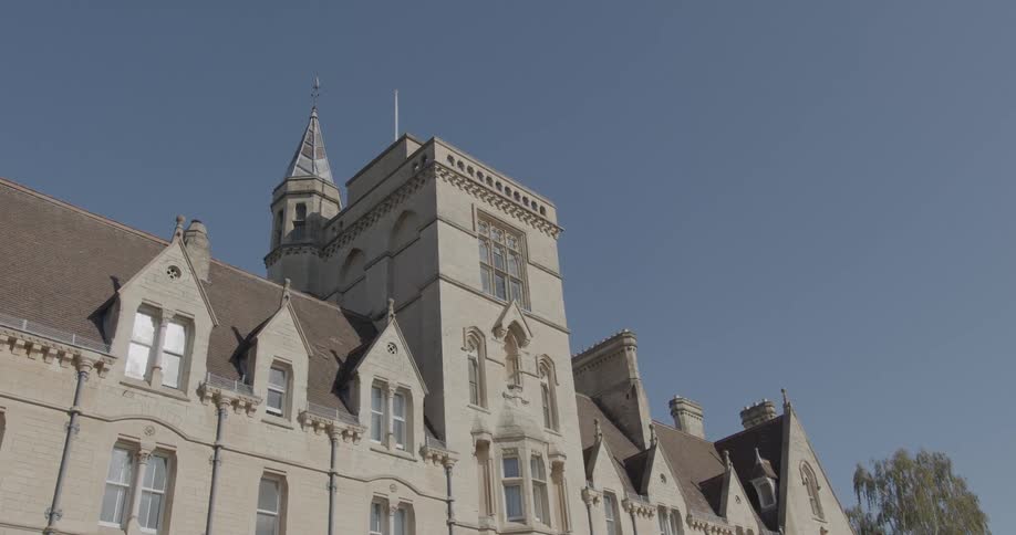 The front part of a building with ancient architecture and several windows in contrast to a blue sky