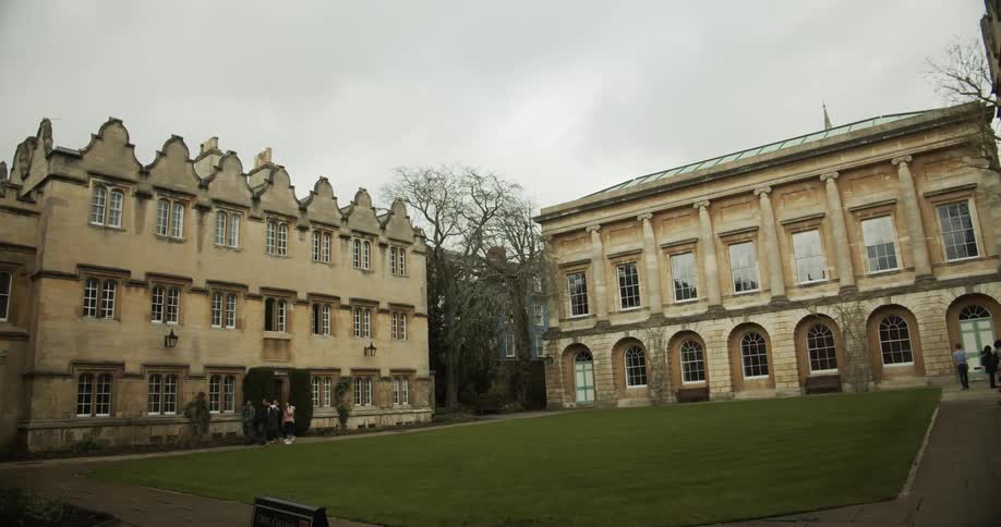 A group of people walk down the sidewalk in a housing courtyard on a cloudy day