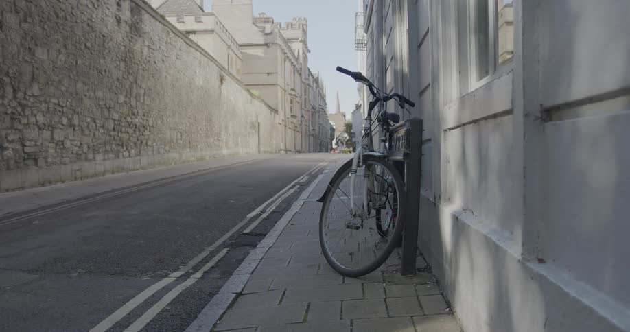Bicycle parked at a lever on a street wall in an urban city
