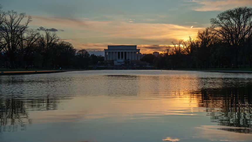 Scenery of a square with a lake and the sun setting on the horizon
