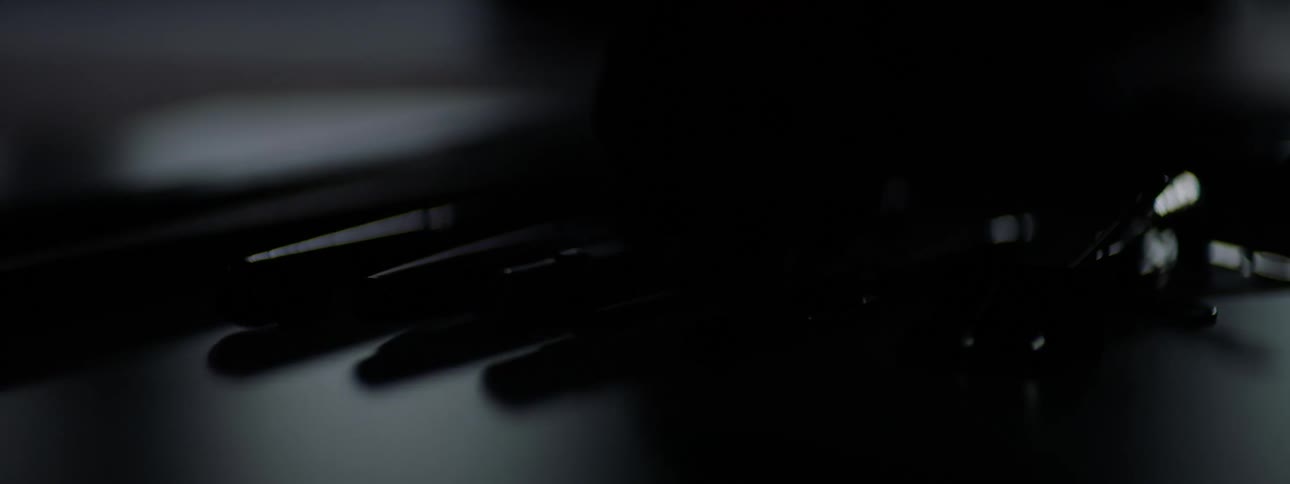 Close up of a hand picking up a pen from a desk